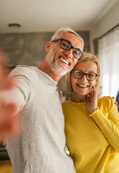 happy retired couple taking a selfie together at home